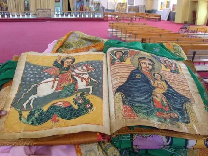 An open book displaying religious images, placed on a surface indoors.